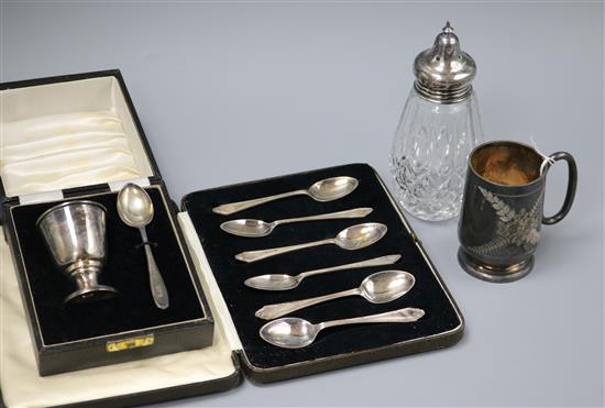 A cased silver christening egg cup and spoon, a set of six silver teaspoons, a silver christening mug and mounted caster.